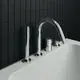 Chromfarbener 4-Loch Wannenrandarm mit Auslauf und Umsteller von Ideal Standard, montiert an einer weißen Badewanne vor schwarzer Fliesenwand.